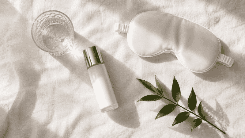 SPF, water, sleep mask and botanicals representing the lifestyle factors that support collagen production — sun protection, sleep and hydration