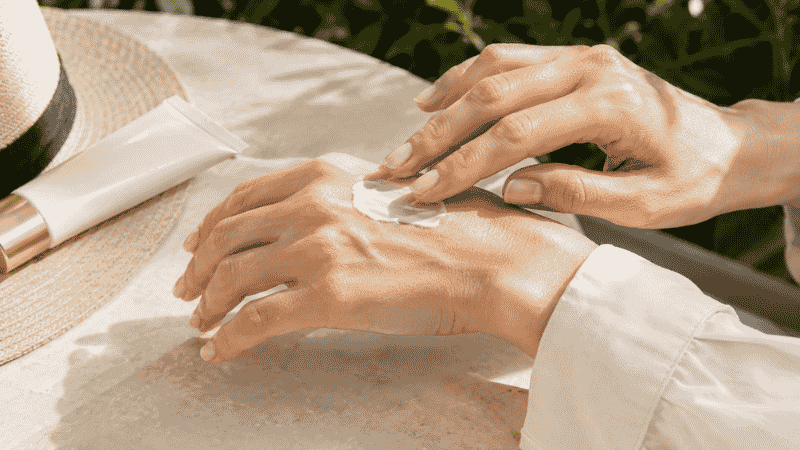 Applying luxury mineral sunscreen in morning light — does sunscreen prevent wrinkles and photoaging for mature skin