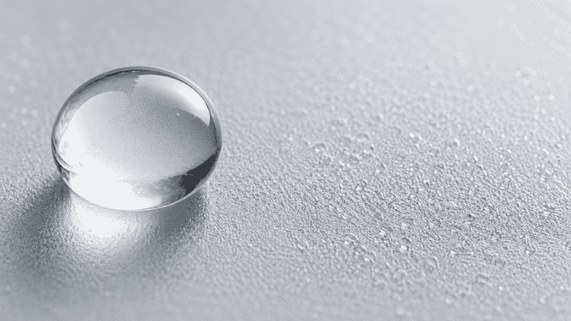 Large and small water droplets on frosted glass — high molecular weight hyaluronic acid vs low molecular weight showing how size determines skin penetration depth