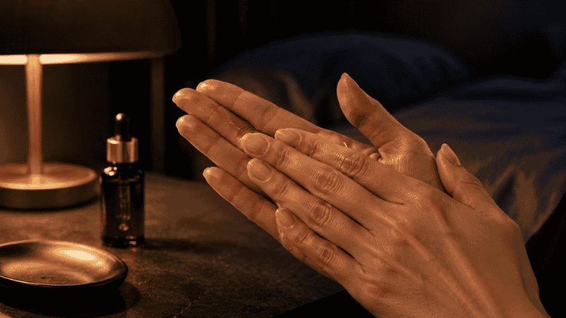 Pressing luxury squalane oil between palms in an evening skincare ritual — how to use squalane oil as the final step in a mature skin routine