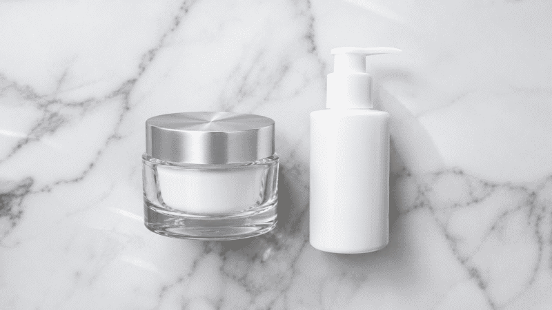 Luxury crystal glass ceramide jar beside functional white plastic pump — is luxury ceramides moisturizer worth the premium over standard barrier cream